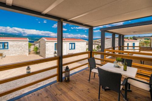 a patio with a table and chairs on a balcony at Mobile Homes Krk Silo in Šilo