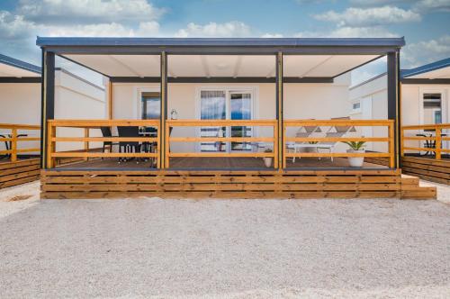 a large house with a large deck with chairs at Mobile Homes Krk Silo in Šilo