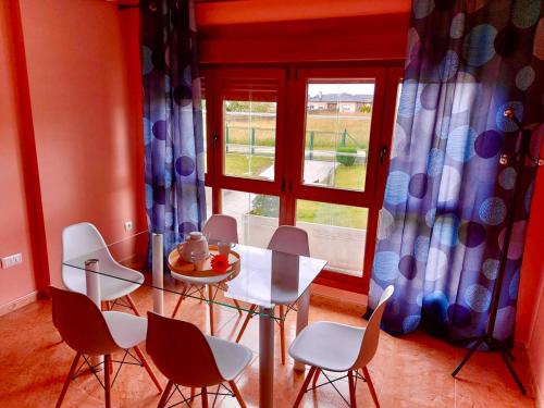 comedor con mesa, sillas y ventana en Casa Eloy, en Barreiros
