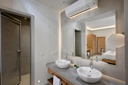 a bathroom with two sinks and a large mirror at Petinos Hotel in Platis Yialos Mykonos
