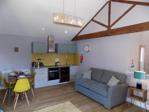 a living room with a couch and a kitchen at The Old Wool House Apartments in Carlisle