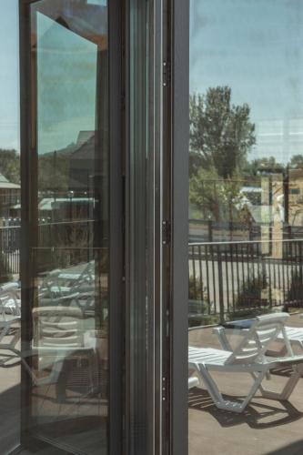 a view of a patio with lawn chairs through a window at Гостиничный комплекс Be Fine in Besqaynar