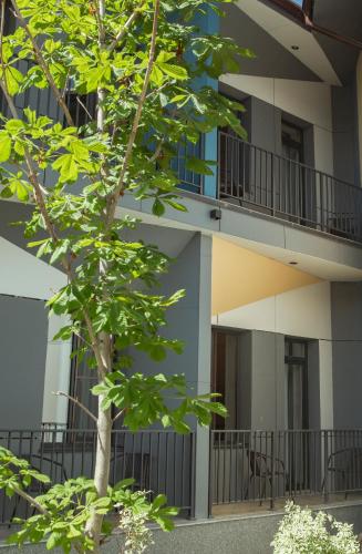 an apartment building with a tree in front of it at Гостиничный комплекс Be Fine in Besqaynar
