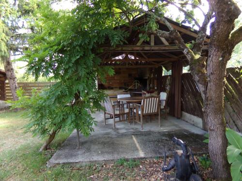 una casa con mesa y sillas bajo un árbol en Chambres d'hotes du Domaine Capiet en Courpiac