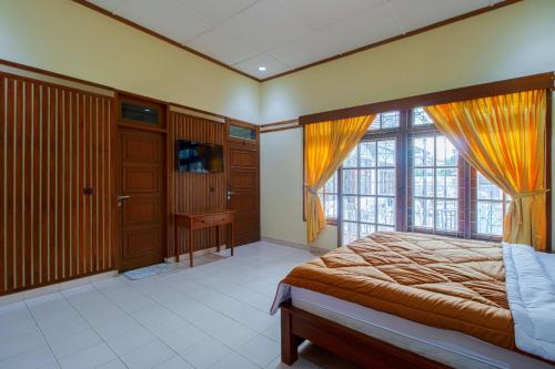 a bedroom with a bed and a large window at Tobana Pejaten House in Jakarta