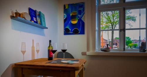 a table with two glasses of wine and a window at Ferienwohnung _Altes Zollamt_ in Neustadt in Holstein