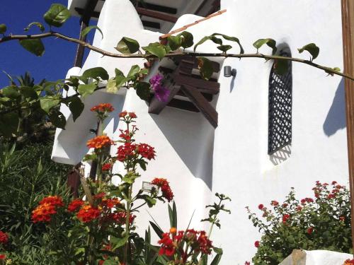 a white church with a cross and flowers on it at Chalet El Encanto in Zahara de los Atunes
