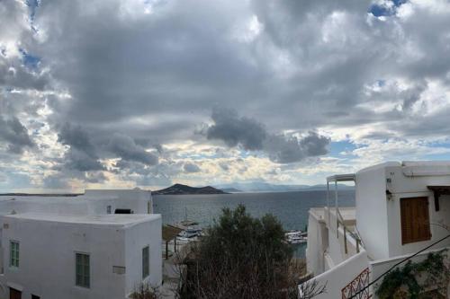 a view of the ocean and buildings with a cloudy sky at Petrino Naxos in Naxos Chora