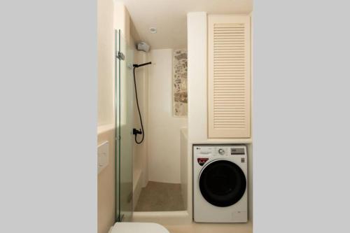 a washing machine in a bathroom with a shower at Petrino Naxos in Naxos Chora