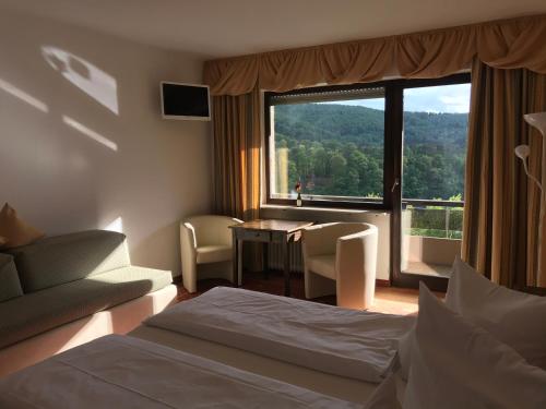 a hotel room with a bed and a large window at Hotel Berghof in Biersdorf am See