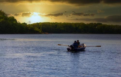 a group of people in a row boat on a lake at Ferienwohnung _Altes Zollamt_ in Neustadt in Holstein