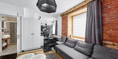 salon z kanapą i ścianą z cegły w obiekcie HEL w Zakopanem