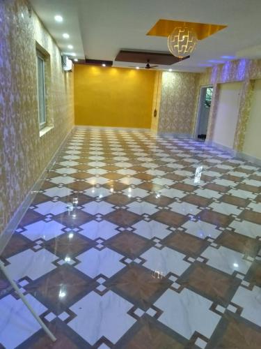 a lobby with a tiled floor with a chandelier at Ratna Resort near Bhubaneswar Airport in Khandagiri