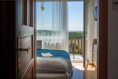 Schlafzimmer mit einem Bett und Blick auf einen Balkon in der Unterkunft Corek in Vrbice