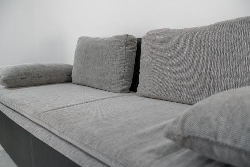 a gray couch with two pillows on it at Apartments The heart of Croatia in Pirovac