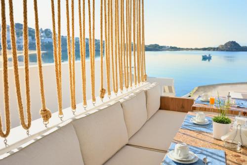 a balcony with a table and a view of the water at Petinos Hotel in Platis Yialos Mykonos
