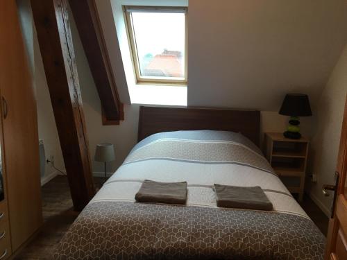 a bed in a small room with a window at gîtes au domaine Greiner in Mittelwihr
