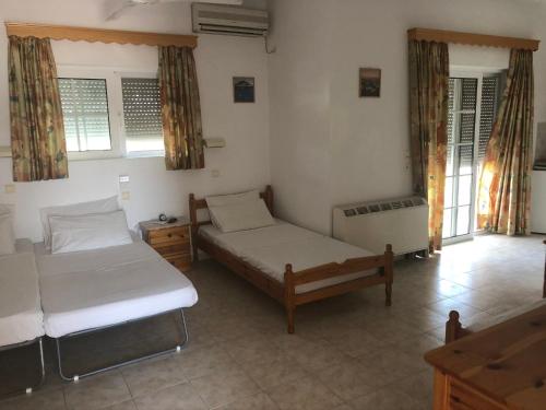 a bedroom with two beds in a room with windows at Peacock Studios in Pefki Rhodes