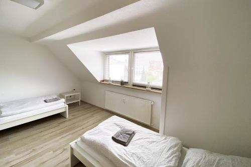 ein weißes Zimmer mit einem Bett und einem Fenster in der Unterkunft Moderne und sehr zentral gelegene Apartments in Neuss