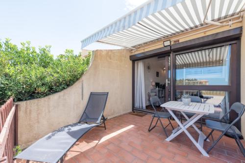d'une terrasse en briques avec une table et des chaises. dans l'établissement La Dune, à Leucate