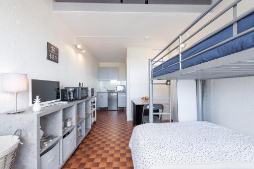 a bedroom with a bed and a bunk bed at La Dune in Leucate