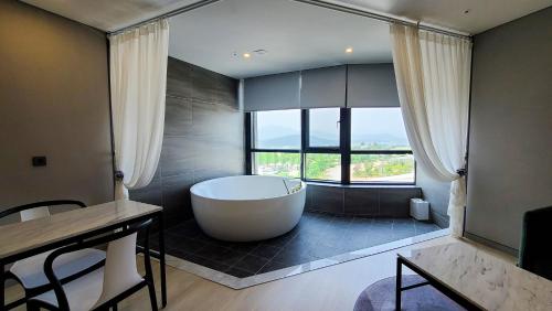 a large bathroom with a tub and a large window at Hotel Ohevday in Namwon