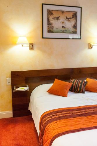 a hotel room with two beds and a picture on the wall at Hôtel Les Tilleuls, Bourges in Bourges