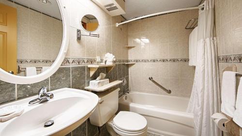 a bathroom with a sink and a toilet and a tub at Best Western Fireside Inn in Kingston