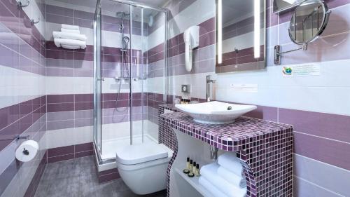 a bathroom with a toilet a sink and a bathtub at Hôtel du Plat d'Etain in Paris