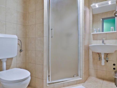 a bathroom with a shower and a toilet and a sink at Korona Panzió in Levél
