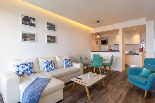 een woonkamer met een bank, stoelen en een tafel bij Monumental Apartment in Funchal