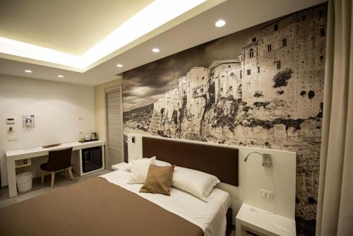 特羅佩阿的住宿－Rooms Dream Tropea，一间卧室配有一张床,墙上挂着绘画作品