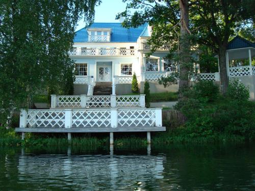 a white house with a bridge over a body of water at Nelijärve Holiday Centre in Aegviidu