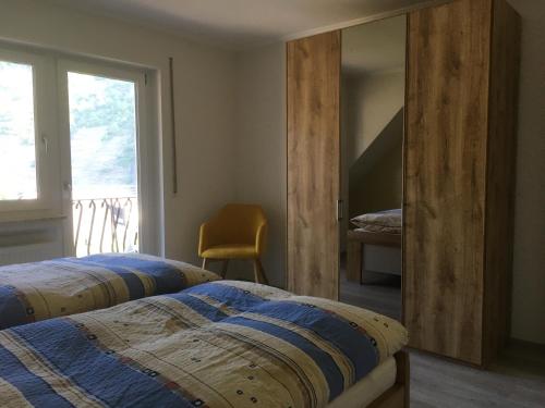 two beds in a bedroom with a mirror and a window at Weinhaus Lenartz-Bleser in Briedern