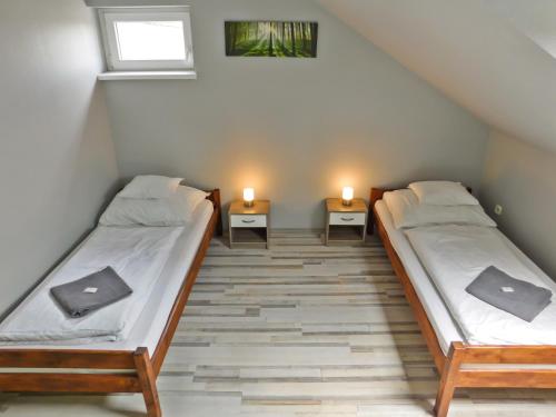 Levél的住宿－Korona Panzió，两张床位于带两盏灯的墙上。