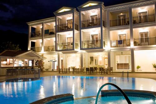 a hotel with a swimming pool in front of a building at Royal Nidri in Nydri