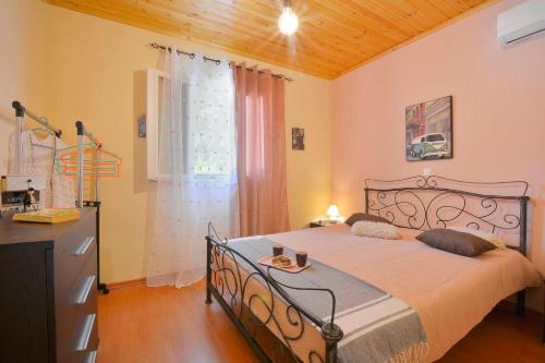 een slaapkamer met een bed, een dressoir en een raam bij Artemis Prasoudi Beach in Chalikounas