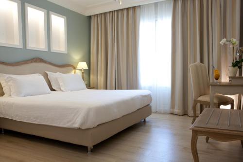 a hotel room with a bed and a table and window at Royal Nidri in Nydri