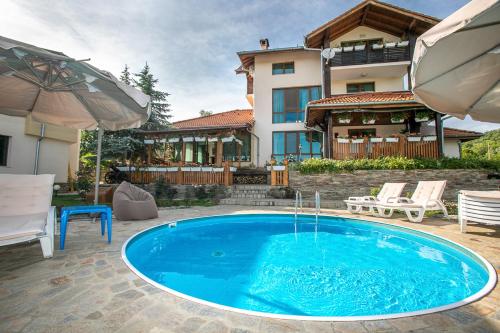 a swimming pool in front of a house at Vila Gardenia in Gumoshtnik