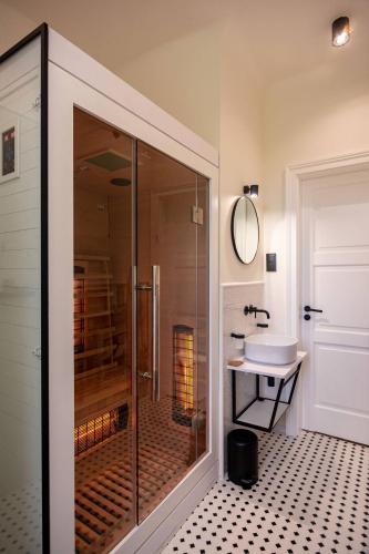een badkamer met een glazen douche en een wastafel bij Apartament Podoficerski z sauną in Puławy