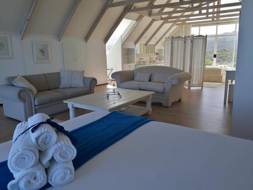 a bedroom with a bed and a living room at Whales Way Ocean Retreat in Wilderness