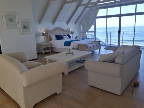a living room with white furniture and a bed at Whales Way Ocean Retreat in Wilderness