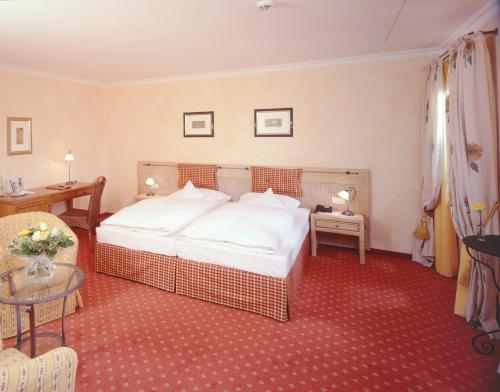 a hotel room with a bed and a table at Hotel und Landgasthof Altwirt in Großhartpenning
