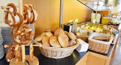 a counter with baskets of pretzels and baskets of bread at Familienhotel nahe der Therme Erding in Erding