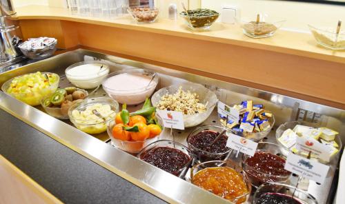 a counter with a bunch of different types of food at Familienhotel nahe der Therme Erding in Erding