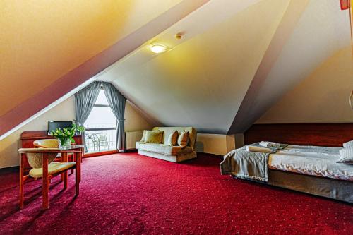 a attic bedroom with a bed and a table at Panorama_SPA in Trzęsacz