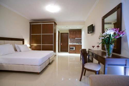 a hotel room with a bed and a desk with a desk at Royal Nidri in Nydri