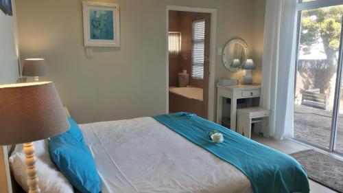 a bedroom with a bed and a bathroom with a mirror at Whales Way Ocean Retreat in Wilderness