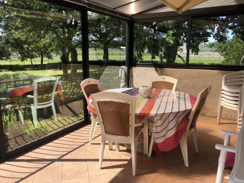 a table and chairs on a patio with a view of a field at Chez Mone et Bon in Onet le Château