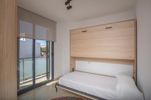 1 dormitorio con cama y ventana grande en Villas Dulcinea de Fantasía Hoteles, en Alcossebre